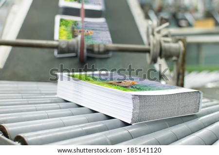 Book, magazine,  production line into press plant house. Automatic assembly line close up