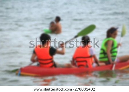 blurred people play boat rubber at sea