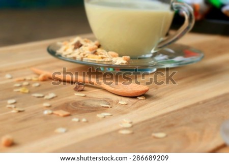 Oat flakes and soybean milk on wooden background.