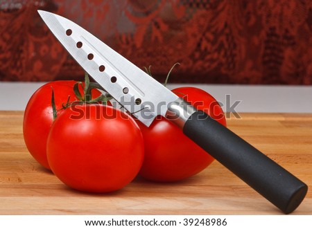 Knife and tomatoes  on cutting board close up