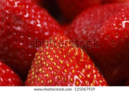 Close up on a bundle of fresh strawberries. Macro shot with shallow focus on the strawberry in the center of the image.