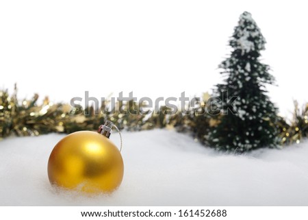Christmas decoration bauble with artificial tree and ornamental garland in the snow. Studio shot, isolated on white background.