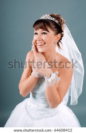 Beauty young bride dressed in elegance white wedding dress  gray studio background