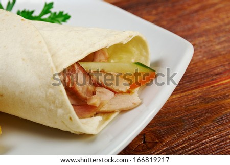 Breakfast burritos made with sausage, scrambled pork,ham, tomatoes wrapped in tortillas