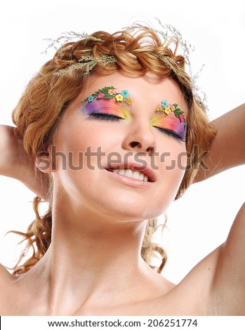 Beautiful girl with bright makeup and eyebrows decorated with flowers isolated on white background. Fantasy girl portrait.  Summer fairy portrait. Long permed hair