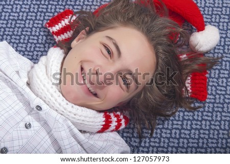 Handsome teenage boy lying on the floor with Christmas hat