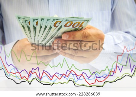 Businessman\'s hands counting money and financial graph - Financial concept