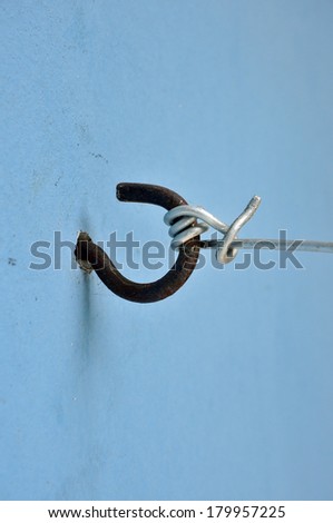 metal hook on blue wall in utility
