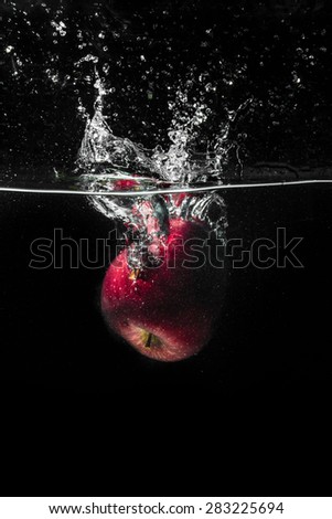 High speed photography of fruits & vegetables with splash in water isolated on black background - APPLE