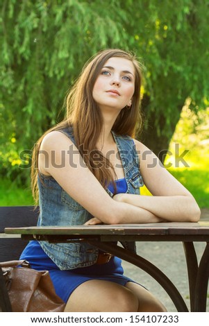 beautiful young woman on the nature, siting at the table