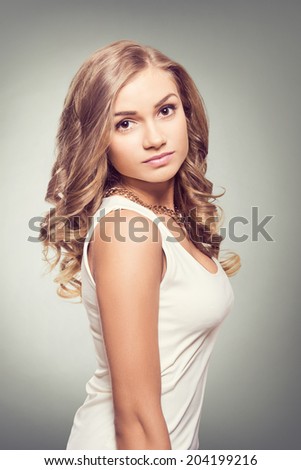Cute blonde woman with brown eyes and long curly hairs. Natural look.