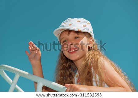 Portrait of little cute girl enjoying playing on boat on a hot sunny day