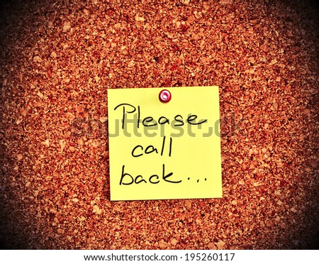 Cork notice board with one yellow sticky note pad with text please call back