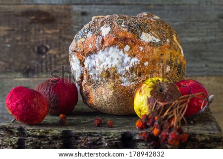 Old and rotten fruit on wooden board