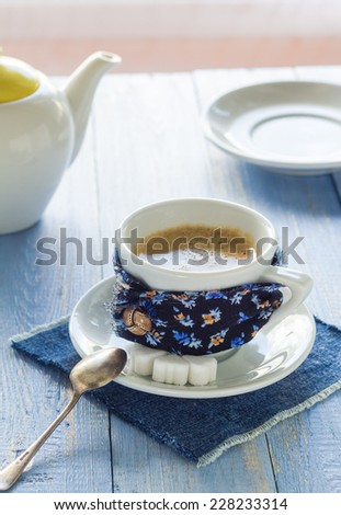 Cup of black coffee with milk on wooden board and jug