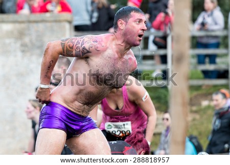 Boughton House, Northamptonshire/UK - May 30, 2015:  A pink-painted Tough Mudder exits the Island Hopper at the Tough Mudder extreme sport challenge raising funds for Help for Heroes.