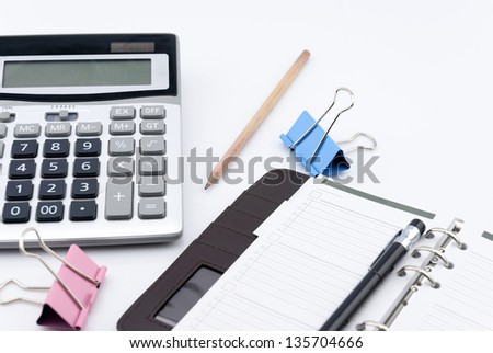 Calculator pen and notebook on white background