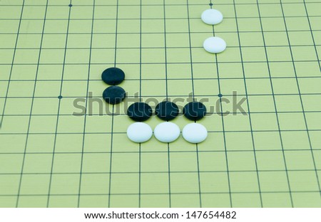 Go game board with black and white stones