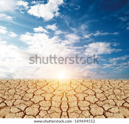 land with dry cracked ground and blue sky