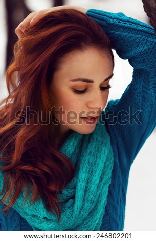 Sensual beautiful woman with red hair and blue blouse being sad