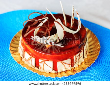 Delicious round cake on blue tablecloth