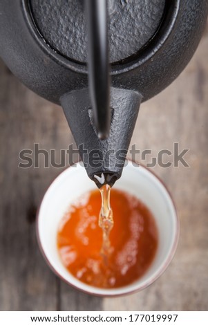 Green tea being poured out of a Japanese teapot