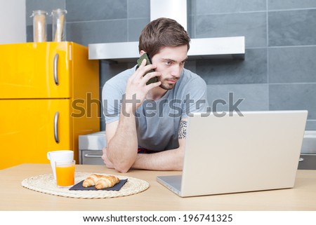 Man phoning looking at the computer