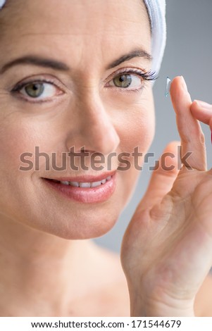 woman in her forties inserting contact lenses