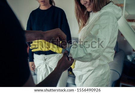 Similar – Woman taping bacteriological protective gloves to a man