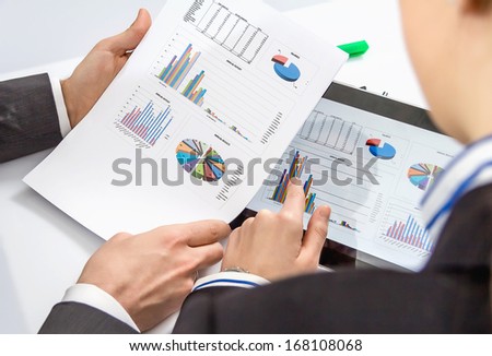 Businesswoman showing financial charts and documents in a digital tablet to the company boss