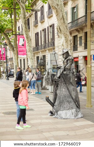 BARCELONA, SPAIN - MAY 31 Childs looking a street artist in the famous and touristic La Rambla street, in Barcelona, Spain, on May 31, 2013
