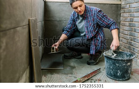 Image, Stock Photo Female mason laying a new tile floor