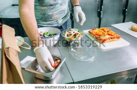 Unrecognizable cook in restaurant kitchen preparing takeaway orders Foto stock © 