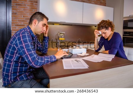 Desperate and unemployed young couple reviewing their credit card debts. Financial family problems concept.