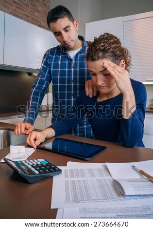 Desperate young woman with many debts reviewing the bills with her guy. Financial problems concept.