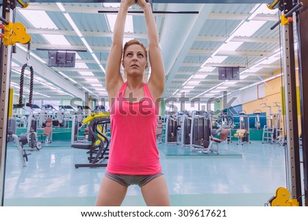 Portrait of beautiful woman stretching her arms in a sport bar before to start a crossfit training on fitness center
