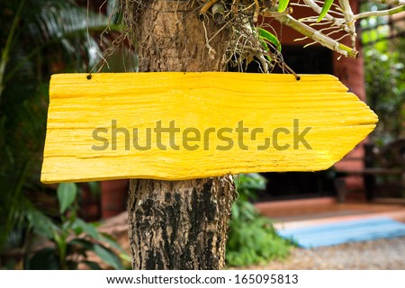 Yellow wooden direction sign board