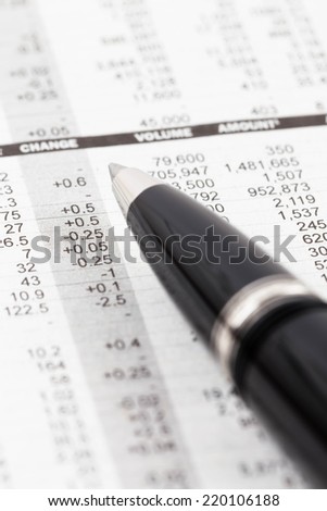 Pen rest on stock price detail financial newspaper