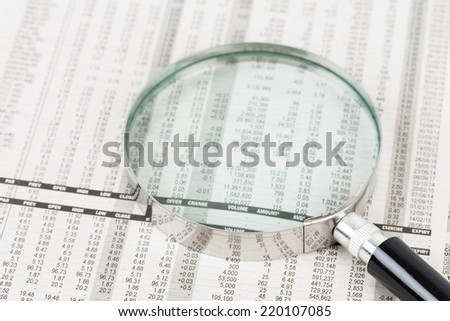 Magnifier rest on stock price detail financial newspaper