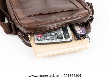 Brown messenger bag with notebook, glasses, and calculator