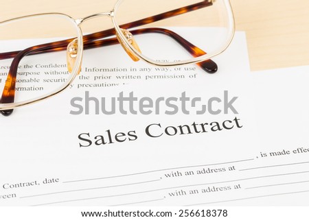 Sales contract document with glasses; document is mock-up