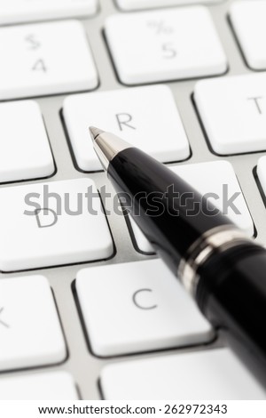 Pen on keyboard concept blog writer