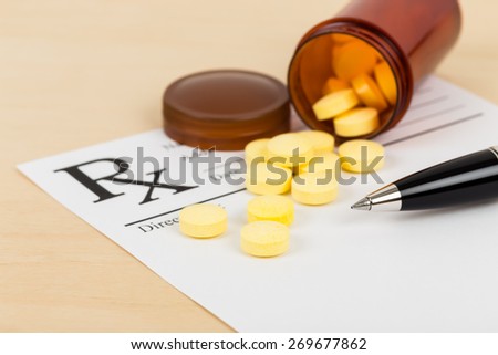 Medicine on blank prescription form with pen focus on pill