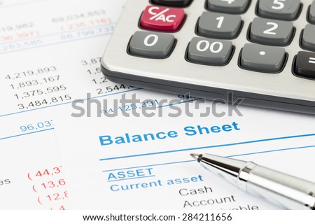 Balance sheet report with calculator and pen; document is mock-up