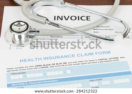 Health insurance claim form and invoice with stethoscope; invoice and form are mock-up