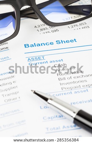 Balance sheet report with glasses; balance sheet is mock-up