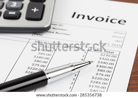 Invoice with pen and calculator; document is mock-up