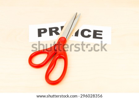 Price in paper cut by scissor on wooden desk concept price cut
