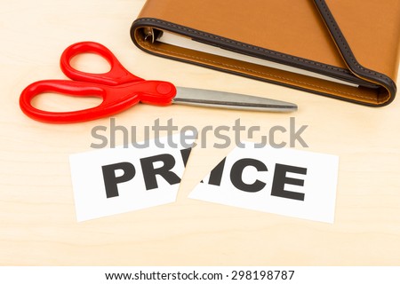 Price in paper cut by scissor on wooden desk concept price cut