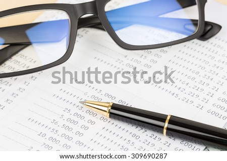 Bank account passbook with pen and glasses